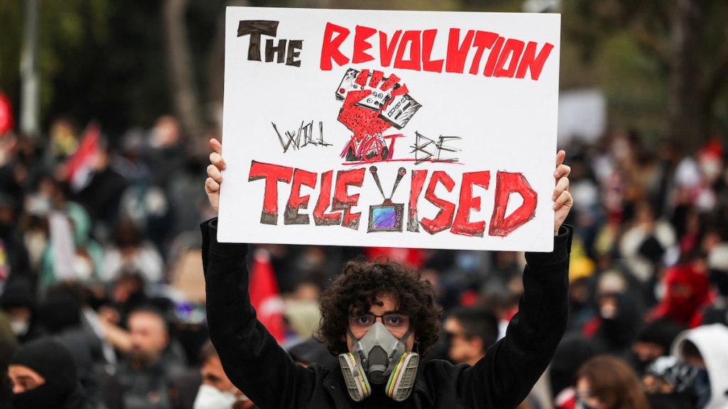 Demonstrant*in in Istanbul mit Gasmaske und Schild "The revolution will not be televised". Von: cpj.org